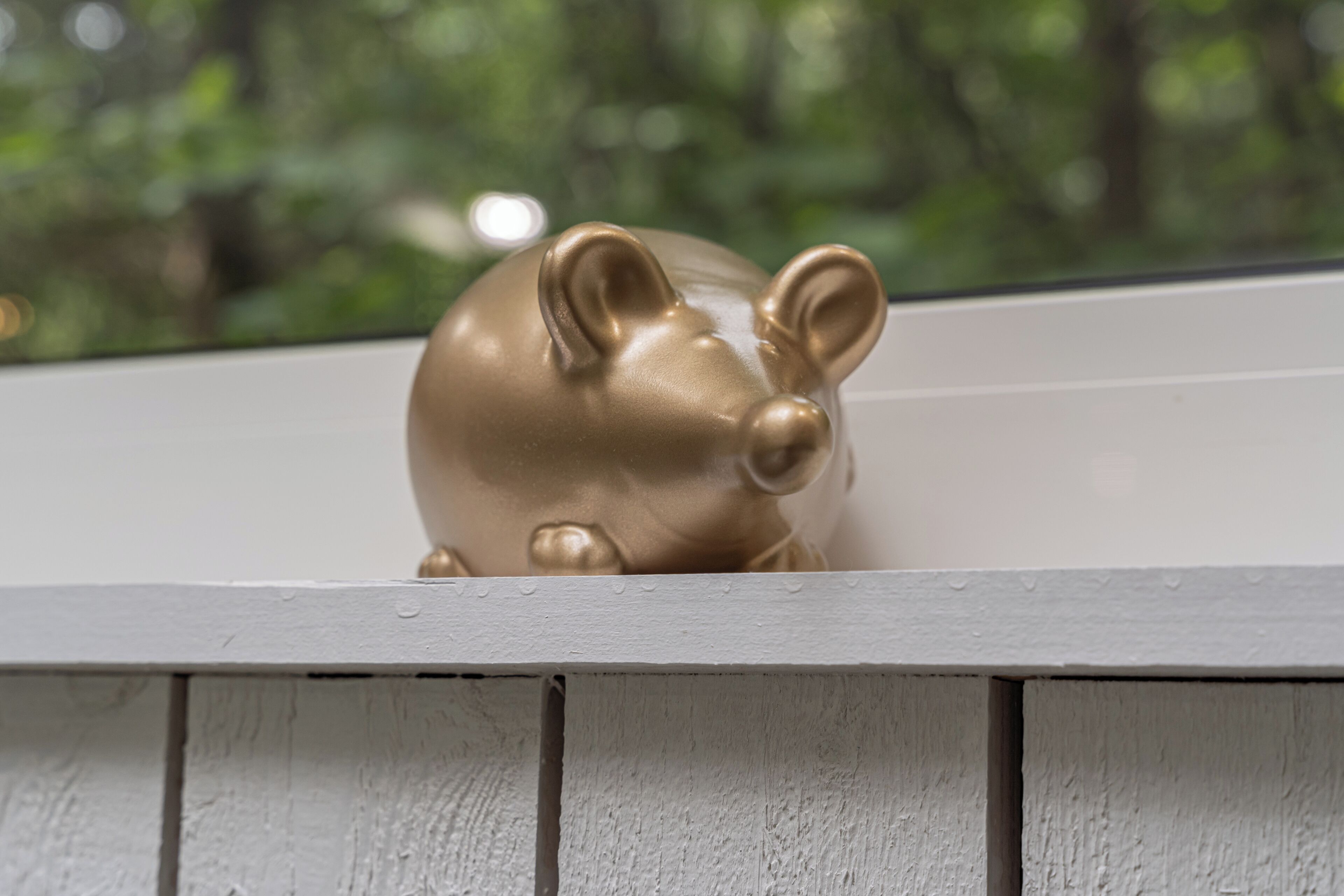 A gold piggy bank on a white ledge.