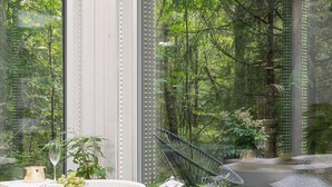 Un bany modern amb banyera, un fanal de vidre i plantes en testos.