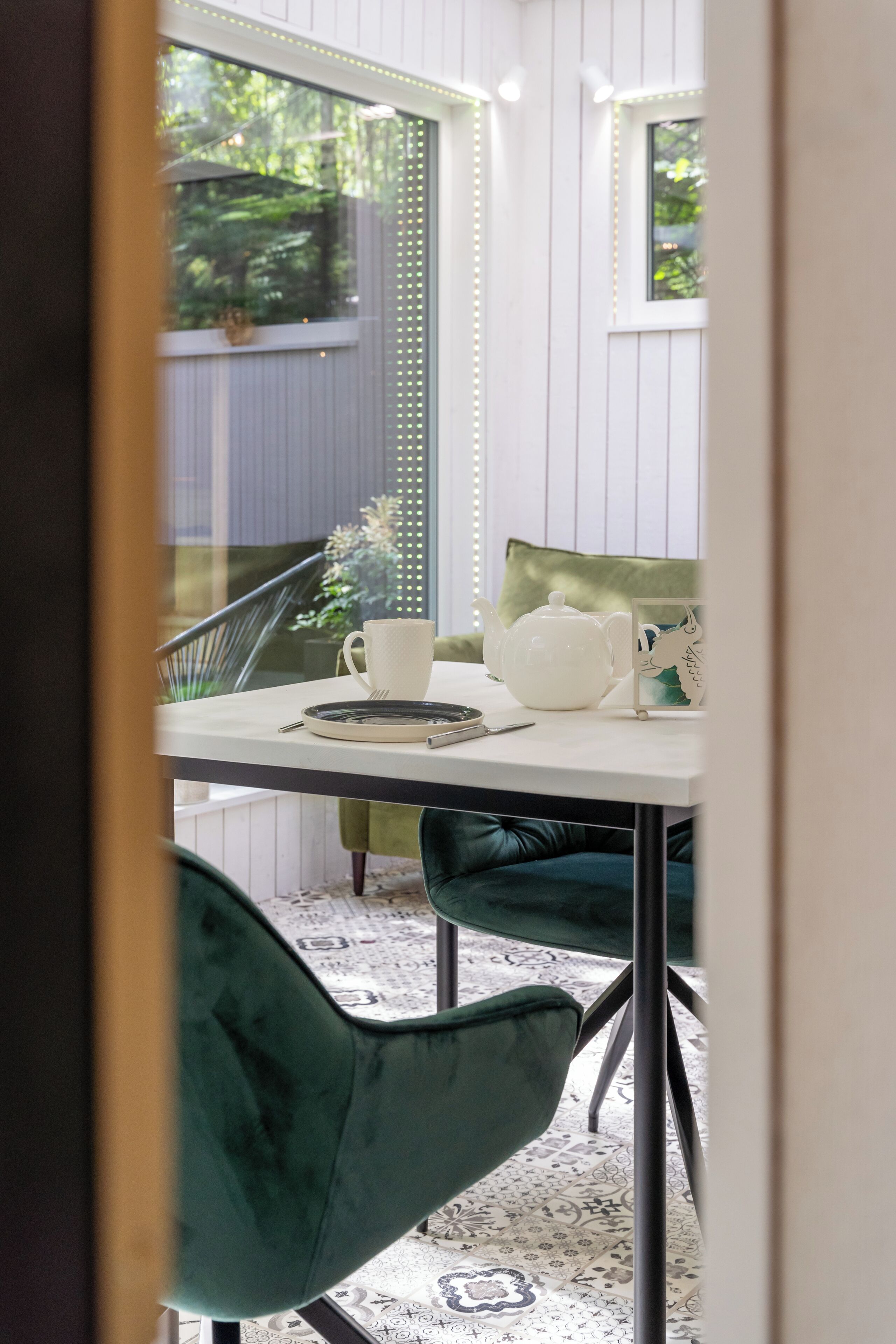 A dining area with a table, chairs, and a teapot.