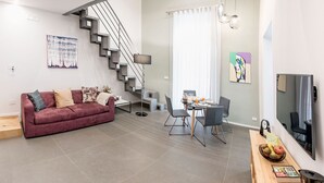 A modern living room with a staircase, a dining area, and a kitchen. - Three houses Toledo (Naples)