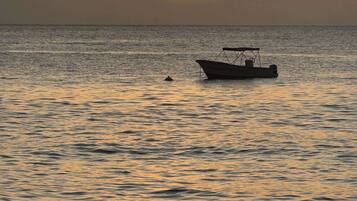 A boat on calm water during sunset.