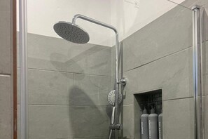 Appartement | Badkamer | Een douche, een haardroger, handdoeken, toiletpapier