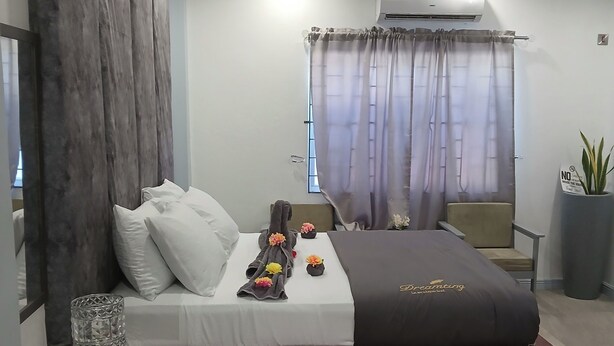 Un dormitorio moderno con cama, mesita de noche, espejo grande, ventana con cortinas y equipo de aire acondicionado.