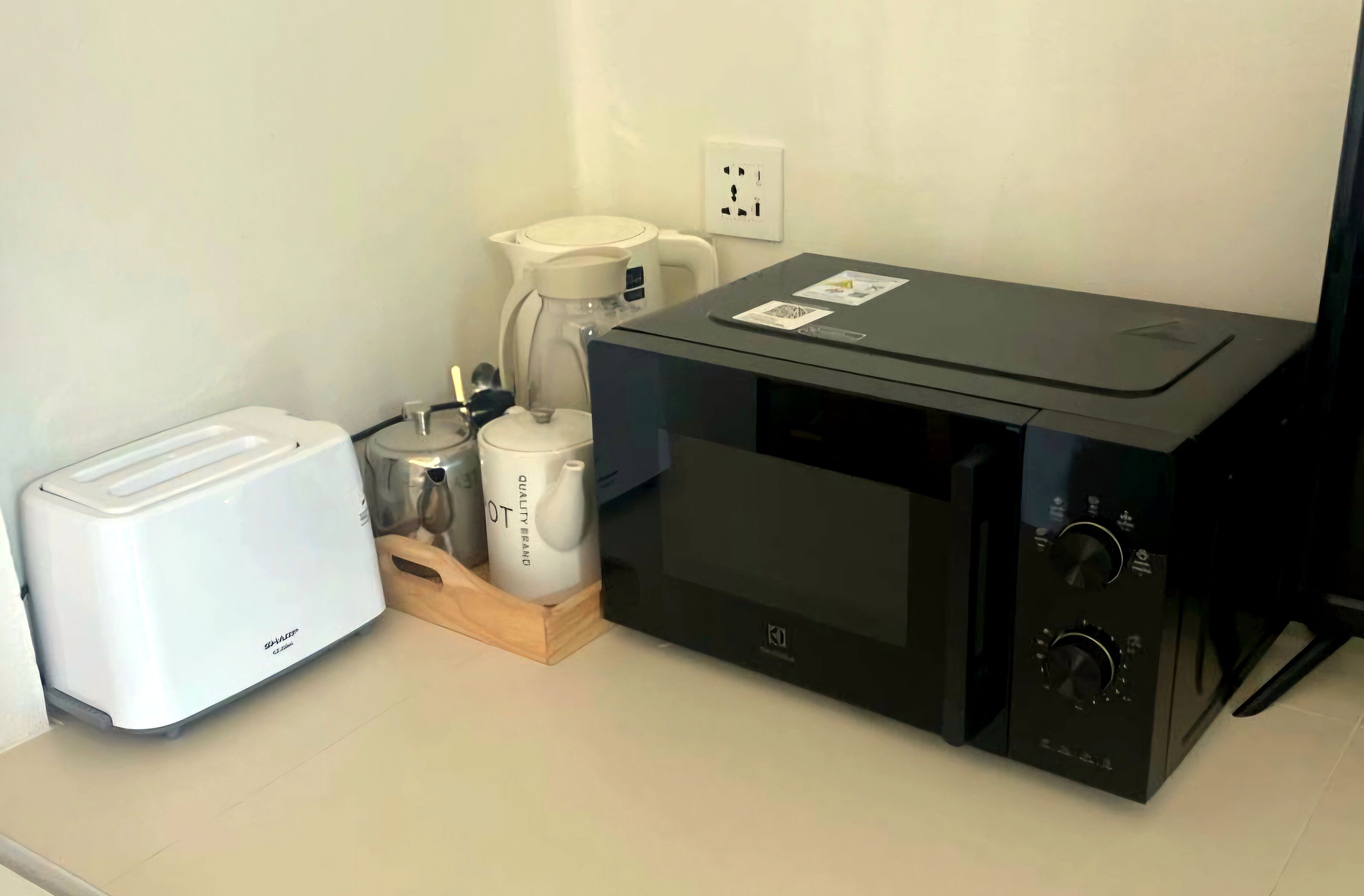 A kitchenette with a toaster, a coffee maker, and a microwave.