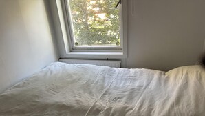 Een kamer met een bed, een raam en een radiator.