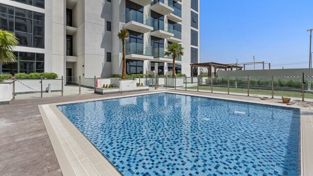 A modern building with a swimming pool. - Elegant Studio with Pool Access  Private Terrace (Dubai)