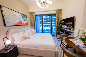 Een hotelkamer met een bed, nachtkastje, televisie en uitzicht.