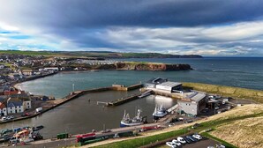 A coastal town with a marina, a large industrial building, and a residential area with houses and a church. - Tranquil Seaside Caravan Retreat in Eyemouth (Eyemouth)