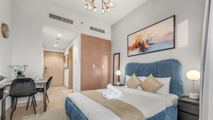 Una habitación de hotel moderna con una cama grande, un escritorio y una silla.