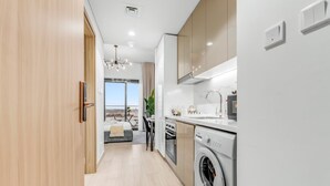 Una cocina moderna con lavadora integrada, un comedor con vistas y un amplio ventanal.