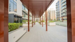 A covered walkway with a modern architectural design, featuring a series of columns and a tiled floor. - Chic Studio Oasis in Dubai (Dubai)
