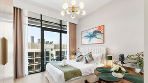 Una camera d'albergo moderna con un letto grande, un'area pranzo e vista sulla città.