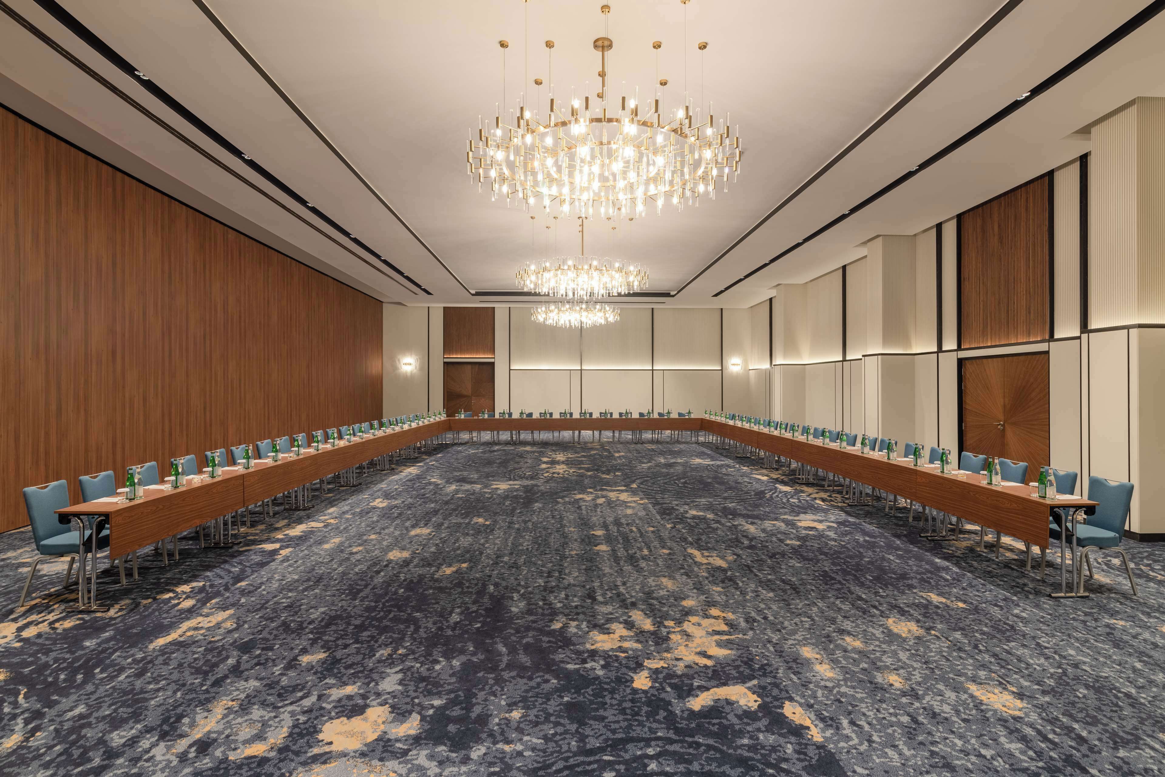 A conference room with a long table, chairs, and a chandelier.
