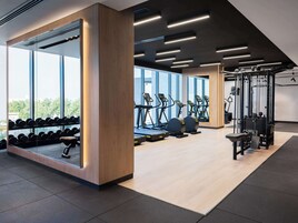 Une salle de sport moderne équipée de tapis de course, d’haltères et d’appareils de musculation.