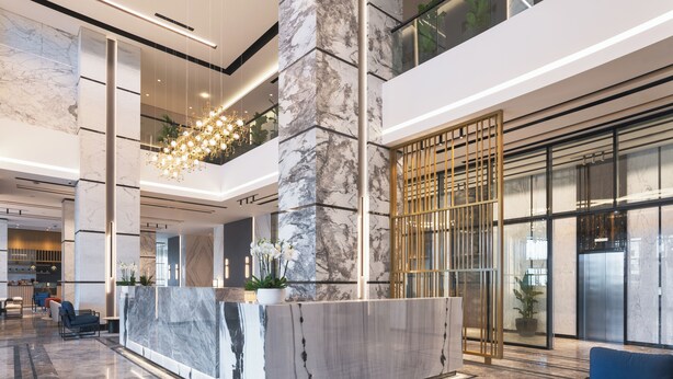A modern lobby with a marble reception desk, blue seating, and a large chandelier. - Park Inn By Radisson Hotel & Apartments Kuwait (Mahboula)