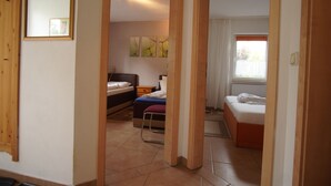 A bedroom with a bed, bedside table, and a window.