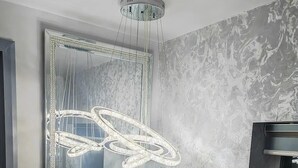 A modern interior with a marble-patterned wall, a large framed mirror, and a unique light fixture. - Cozy Blackpool Retreat With 3 Bedrooms (Blackpool)