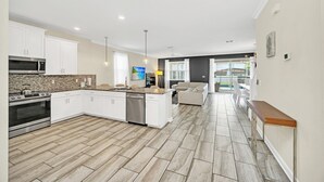 A modern kitchen with white cabinets, a built-in microwave, and a stainless steel oven. - EV_9036 - 9 Bed 5 Bath Villa with Screened-In Private Pool with Spillover Spa (Davenport)