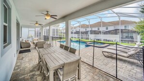 A covered patio with a pool, outdoor furniture, and ceiling fans. - EV_9036 - 9 Bed 5 Bath Villa with Screened-In Private Pool with Spillover Spa (Davenport)