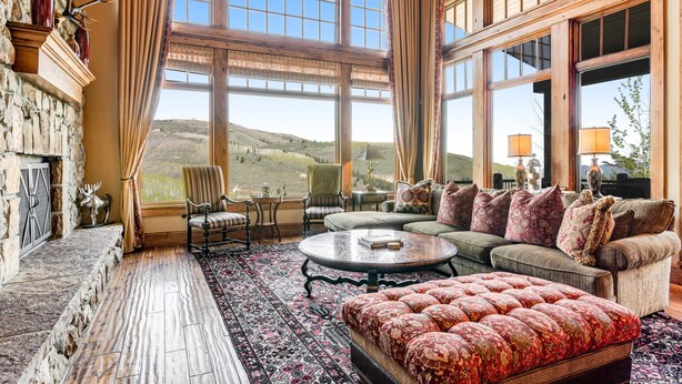 A spacious living room with a large window, a fireplace, and a cozy seating area. - Gorgeous Deer Valley Home Minutes From the Slopes (Park City)
