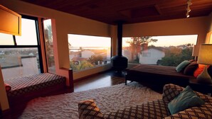 Une pièce confortable avec un lit, un canapé et une fenêtre donnant sur un paysage magnifique.