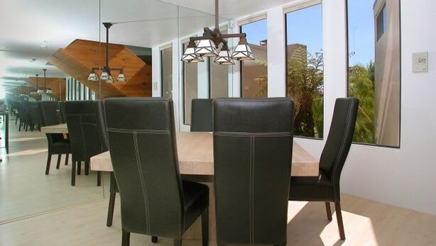 A modern dining area with a large table, black chairs, and pendant lighting. - Stunning View Mission Bay Luxury Home Private Pool (San Diego)