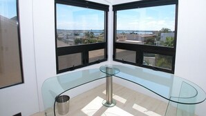 A modern room with a glass table and two large windows offering a view of the city and sea. - Stunning View Mission Bay Luxury Home Private Pool (San Diego)