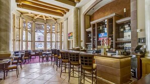 A bar area with wooden chairs and a bar counter, large windows, and a stone column. - Private Residence 3 in Park City (Park City)