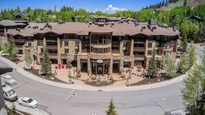 A multi-story hotel with a central courtyard, surrounded by trees and a hilly landscape. - Private Residence 3 in Park City (Park City)