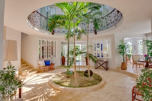 Relax in a spacious interior with a central seating area and staircase leading to an upper level.