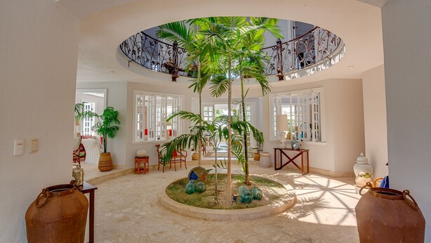 A spacious atrium with a central garden, large windows, and a curved staircase. - Villa Tortuga in Punta Cana (Punta Cana)