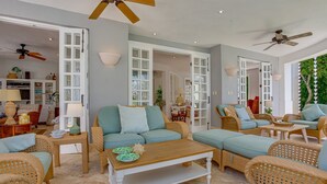 A spacious living area with wicker furniture, a wooden coffee table, and a ceiling fan. - Villa Tortuga in Punta Cana (Punta Cana)