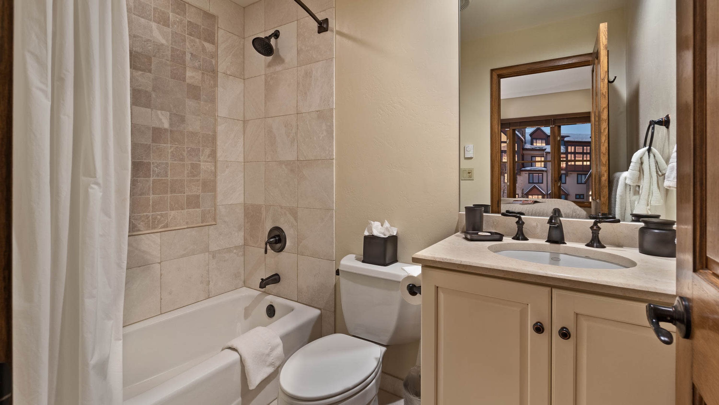 A bathroom with a bathtub, toilet, and sink.