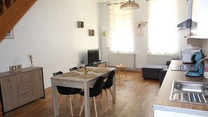 Une cuisine compacte avec un coin repas, un plancher en bois et une cuisinière intégrée.
