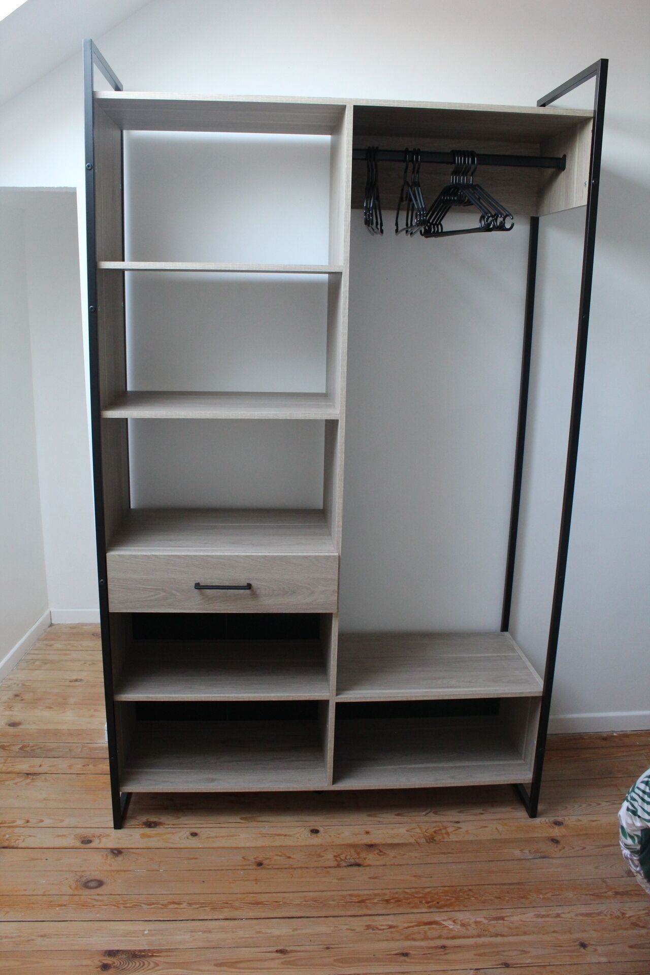 En walk-in garderobe med mange hylder og en bøjlestang.