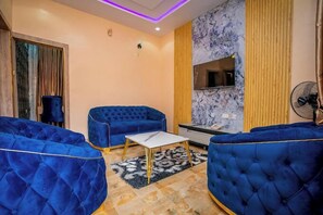 Habitación Deluxe, balcón, vista a la ciudad | Área de sala de estar