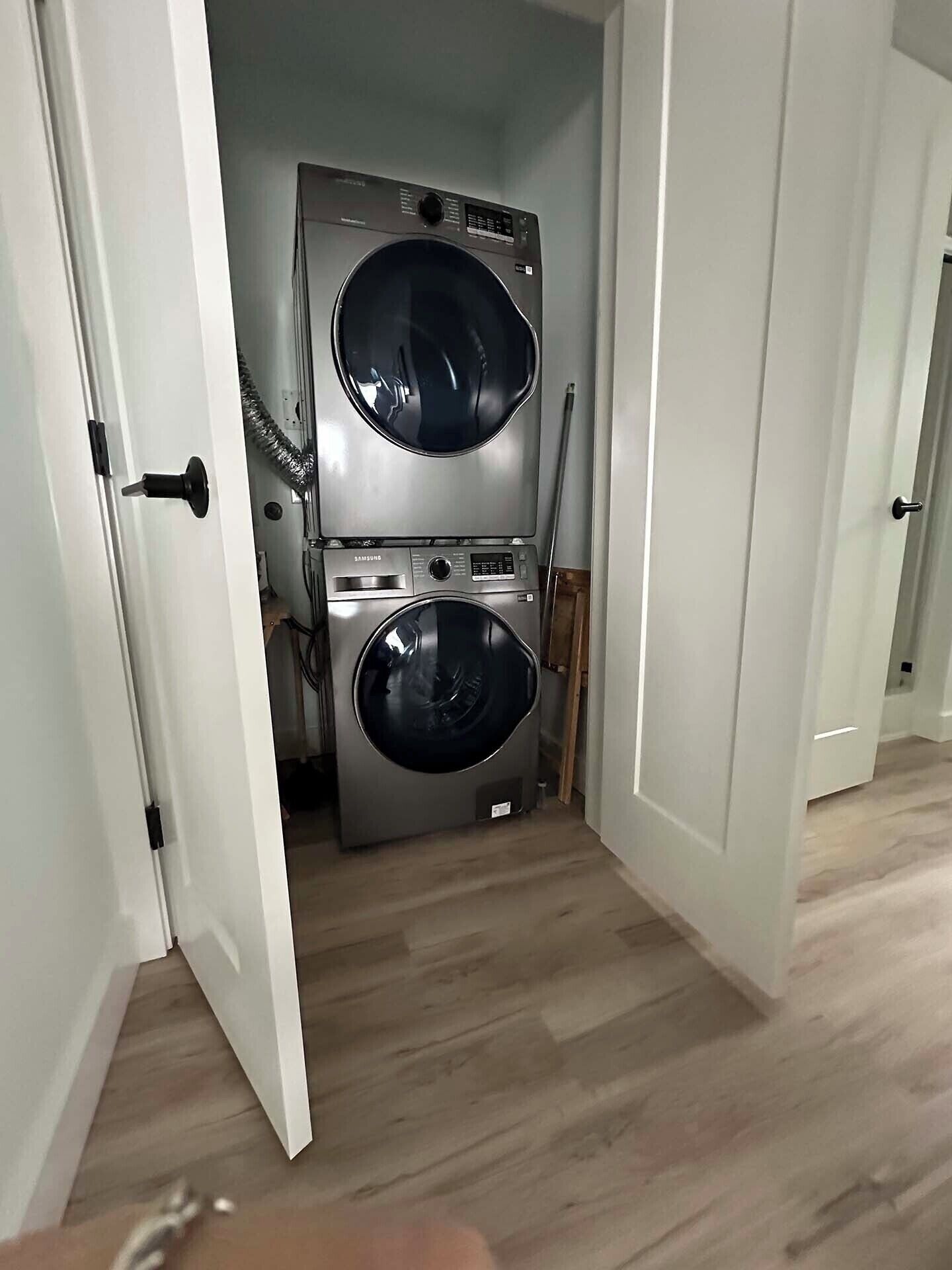 A laundry room with two stacked front-loading washing machines.