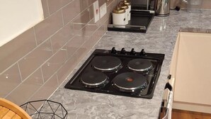 Een moderne keuken met een gasfornuis, een ingebouwde oven en een magnetron.