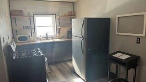 A compact kitchen with a refrigerator, stove, and microwave. - Rhine Suite at Brickhouse Inn (Hermann)
