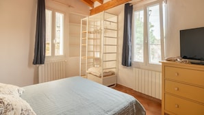 A bedroom with a bed, a wardrobe, a TV, and a window with curtains. - Aperol in Iseo With 1 Bedrooms and 1 Bathrooms (Iseo)
