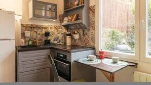 A compact kitchen with a built-in oven, a microwave, and a sink. There is a window providing a view of the outdoors. - Aperol in Iseo With 1 Bedrooms and 1 Bathrooms (Iseo)