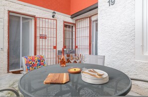 A dining area with a round table, chairs, and a bottle of wine. - Aperol in Iseo With 1 Bedrooms and 1 Bathrooms (Iseo)