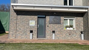 Un bâtiment à deux étages, doté d’une façade en pierre, d’un toit plat et d’une petite antenne parabolique.
