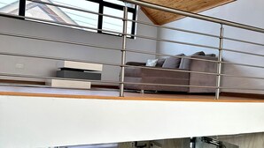 Ein modernes Loft mit einer Zwischenebene, einer Küche inklusive Herd und einem Essbereich.