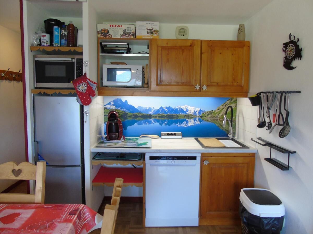 A compact kitchen with a refrigerator, microwave, coffee maker, and dishwasher.