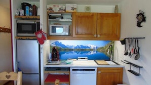 A compact kitchen with a refrigerator, microwave, coffee maker, and dishwasher. - 5th floor, view mountain, balcony, tv, ski locker, 34m², Valfréjus (Valfréjus)