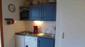 Una cocina compacta equipada con microondas, cafetera y lavavajillas.