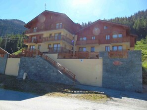 A multi-story building with balconies, a stone staircase, and a sign indicating a restaurant. - 1st floor, view mountain, balcony, tv, ski locker, 48m², Valfréjus (Valfréjus)