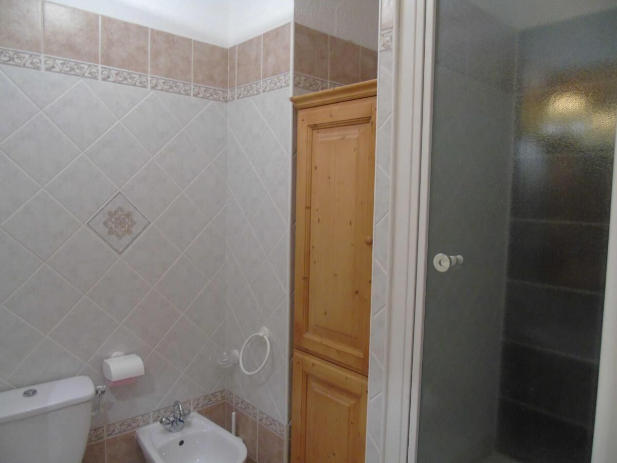 Een badkamer met toilet, bidet en douchecabine.