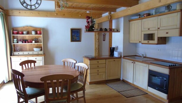 A cozy kitchen with wooden cabinets, a dining table, and chairs. - 8th floor, view resort, balcony, tv, ski locker, 76m², Valfréjus (Valfréjus)
